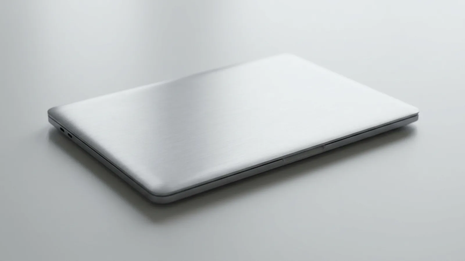 A generic modern aluminium laptop closed on a clean studio desk under soft light, representing a locked-out Mac