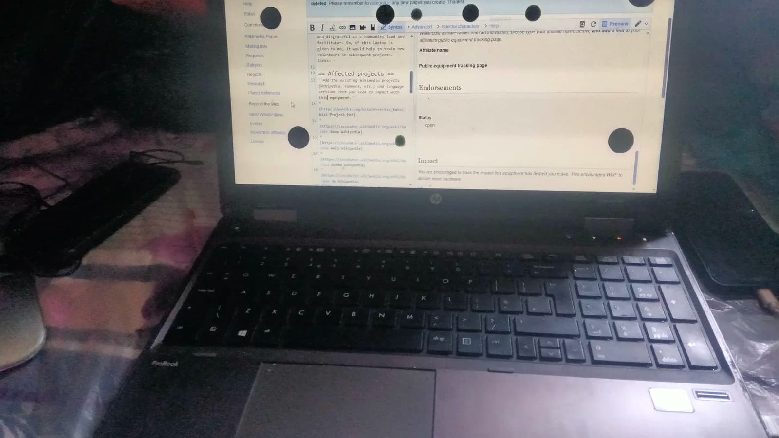 一台打开的 HP 笔记本正显示一个网页，屏幕上有几处蔓延的黑色斑块