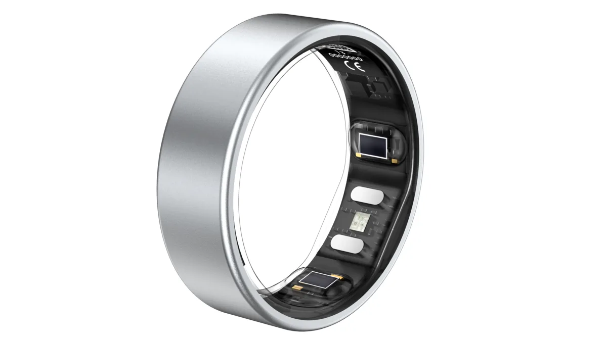 An Actxa Core Smart Ring in brushed silver, tilted to show the inner face with its optical sensor windows, charging contacts and circuitry, on a plain white background