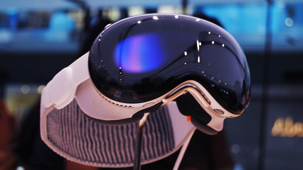 An Apple Vision Pro headset on display, seen from the front with its front glass lit