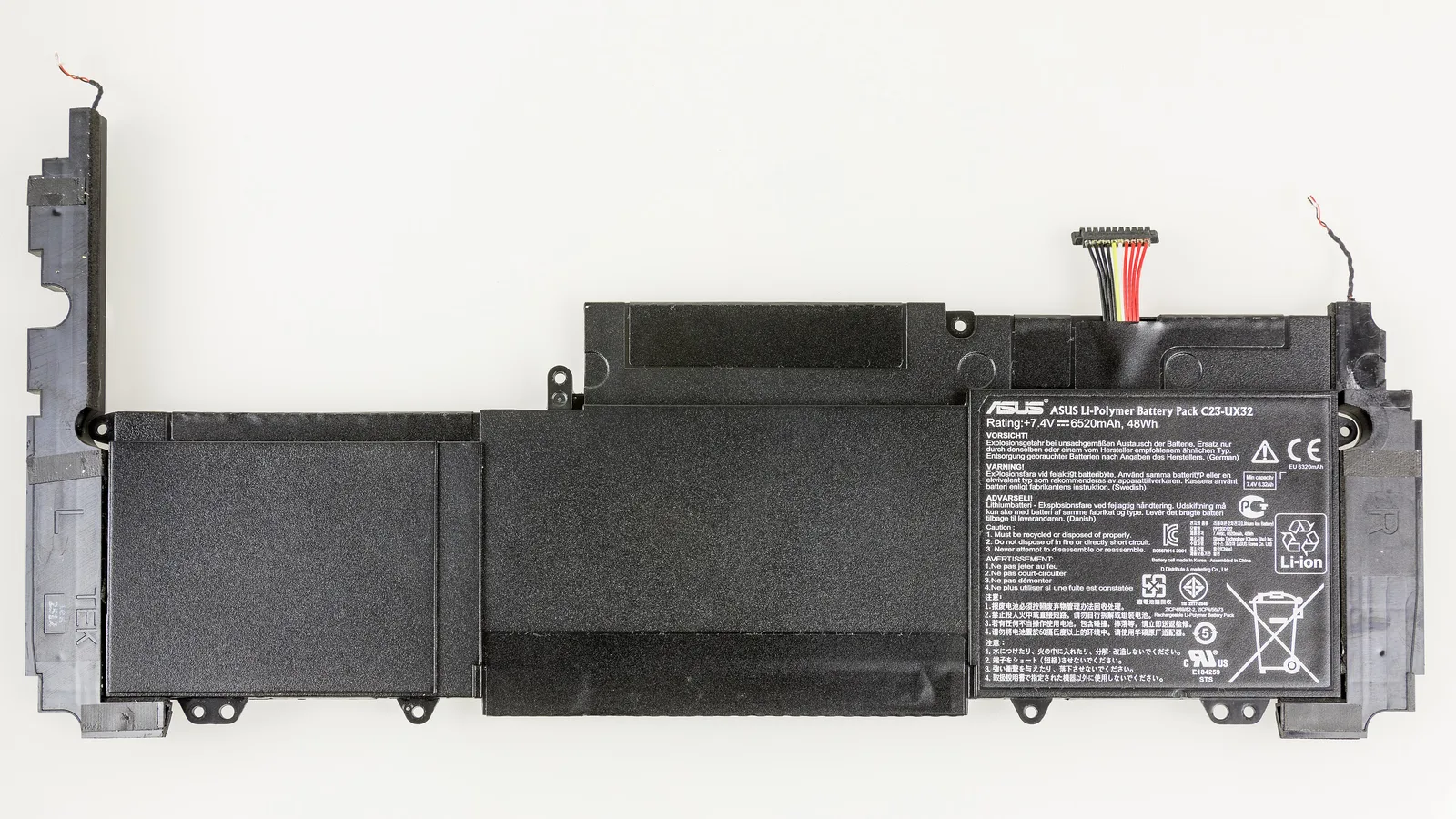 Pek bateri litium-polimer Zenbook hitam nipis berlabel ASUS dilihat dari atas pada latar belakang putih, menunjukkan beberapa sel rata segi empat, label spesifikasi bercetak, penyambung wayar pendek di satu penjuru dan pembesar suara panjang nipis di sepanjang tepi kiri