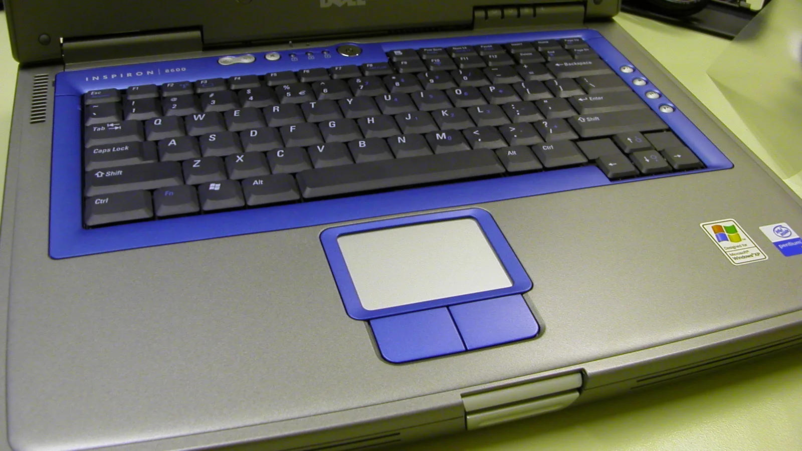 Gambar dekat papan kekunci laptop gelap dengan kekunci memenuhi bingkai.