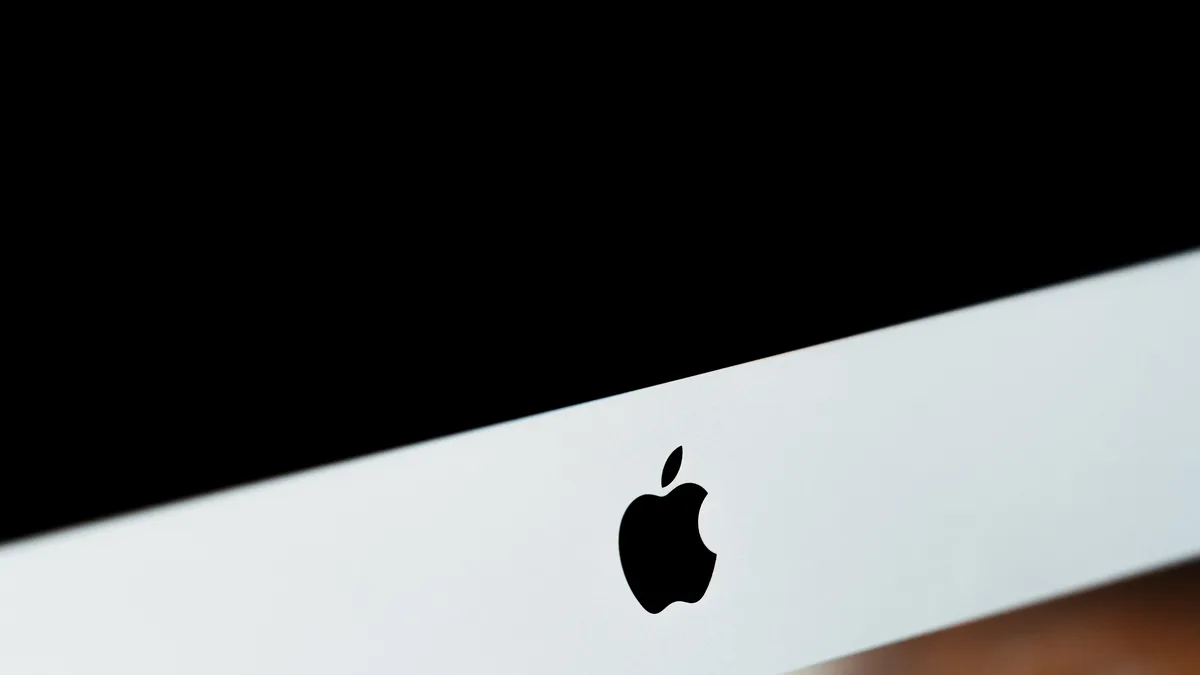 A close view of an aluminium iMac, its dark screen filling the upper frame above the slim silver chin
