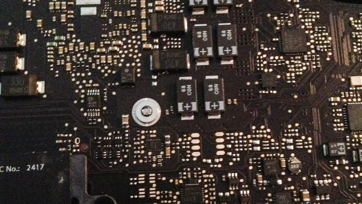 MacBook Pro 逻辑板特写:芯片与电容全部平贴焊接在深色电路板上
