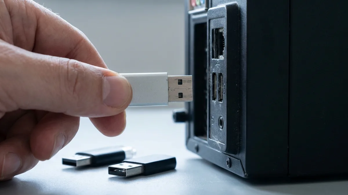Hand unplugging a USB device from the rear ports of a desktop tower to rule out a peripheral conflict