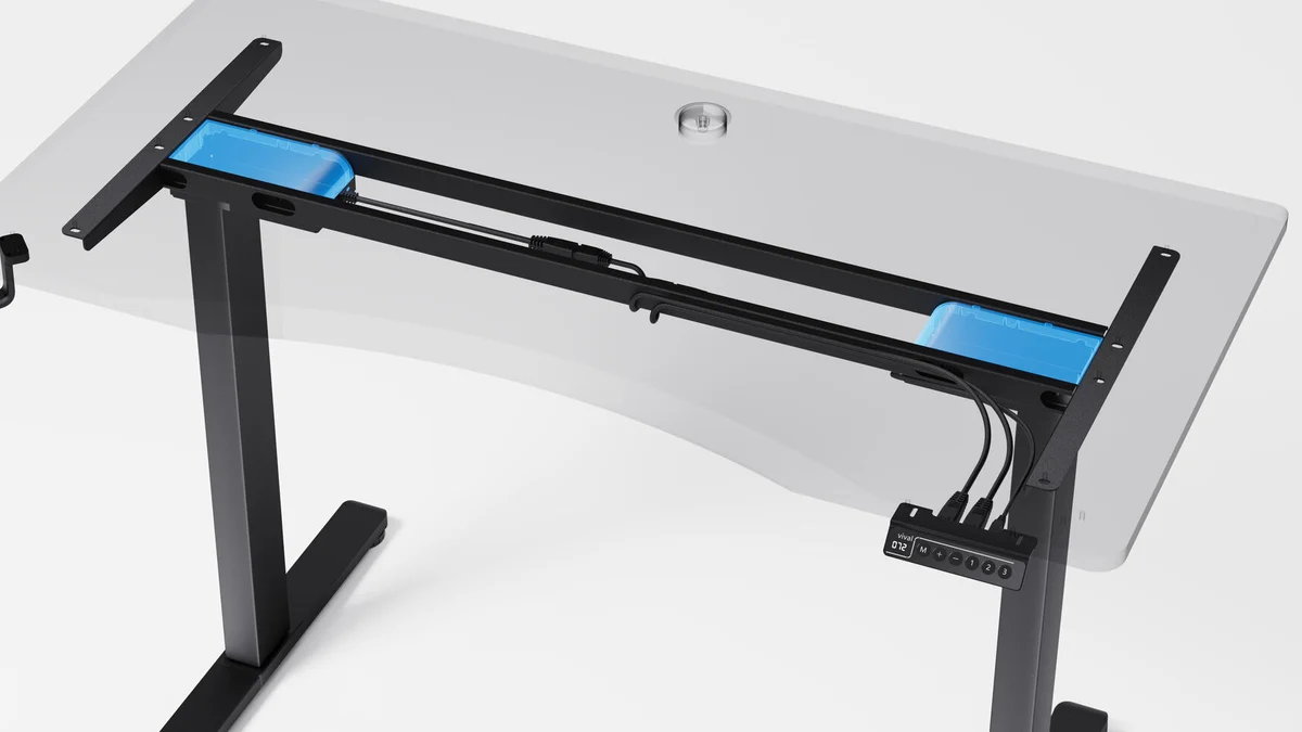A cutaway view of the Vival desk with the tabletop shown as clear glass, revealing a blue motor housed inside each frame rail, the cable channel running between them and the controller under the front edge.