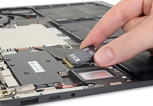 Technician upgrading SSD on a Microsoft Surface device to improve storage and performance